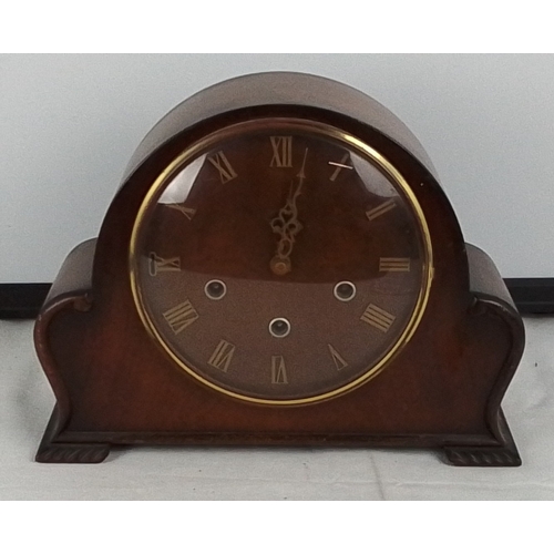 372 - A vintage domed mantel clock with arched case, Roman numeral dial, and three winding arbors, fitted ... 