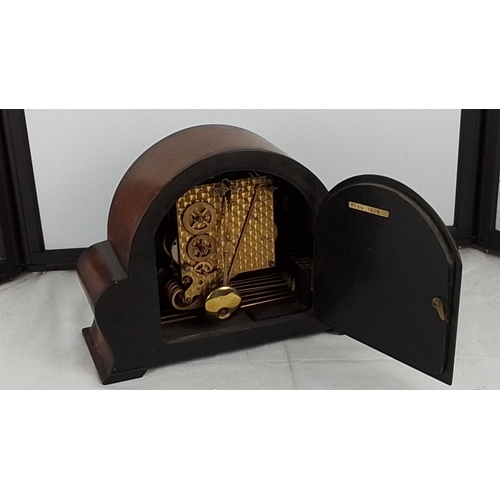 372 - A vintage domed mantel clock with arched case, Roman numeral dial, and three winding arbors, fitted ... 