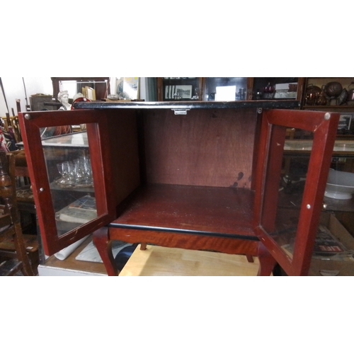 431 - A small mahogany occasional cabinet, the rectangular top above a pair of glazed doors with twin bras... 