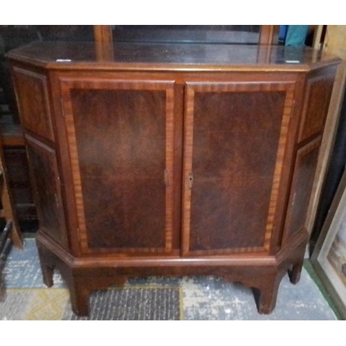 440 - A wood octagonal cabinet/TV cabinet, raised on shaped legs, with two front doors and panelled sides,... 