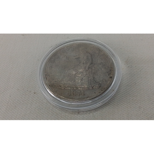 253 - One United States silver dollar coin, dated 1874, in a clear protective capsule; obverse with seated... 