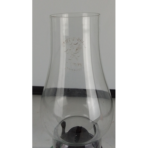 290 - A vintage green glass oil lamp with twin scroll handles, clear glass chimney etched with an eagle mo... 