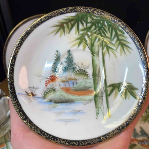 607 - A group of Kutani style Japanese porcelain tea and coffee wares, hand-painted with landscape scenes ... 