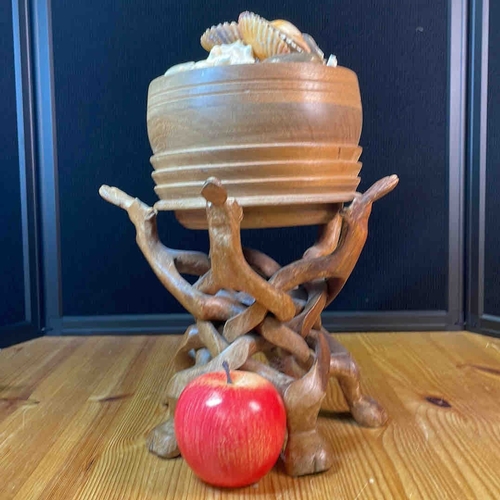 608 - A carved wooden bowl on a sculptural interlaced branch-form stand, presented with assorted seashells... 