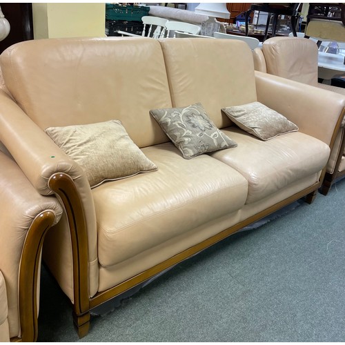 583 - A cream coloured two seater sofa, two matching armchairs and a matching tub chair.