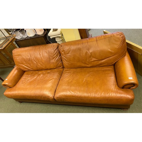 591 - A large tan coloured sofa.