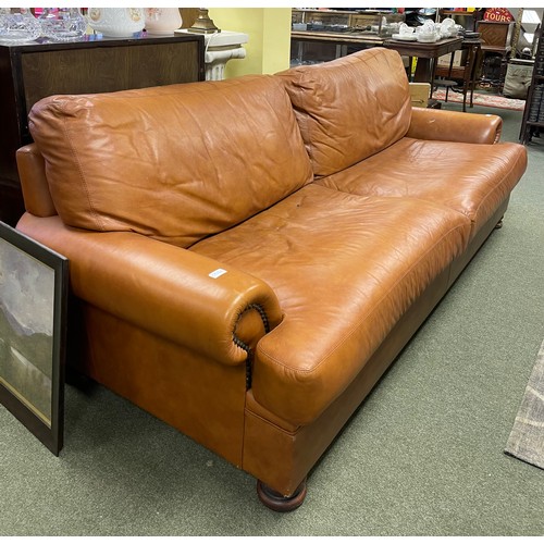 591 - A large tan coloured sofa.