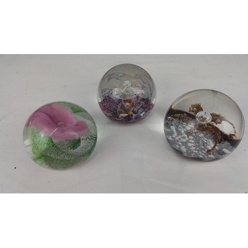 A group of art-glass paperweights, including three domed examples with ...
