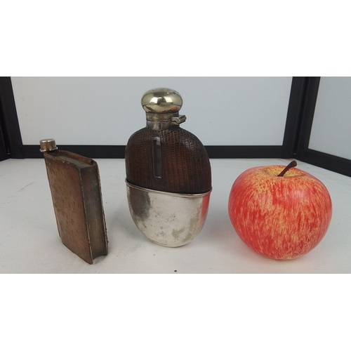 62 - A group of two liquor flasks: one in brown leather sleeve with screw-cap, the other ovoid with brown... 