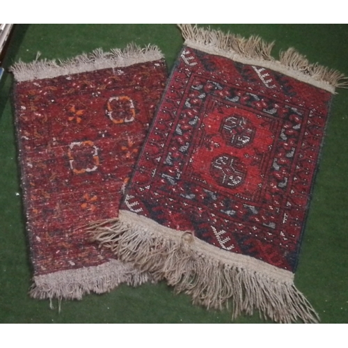 105 - A pair of small wool pile rugs, each with geometric medallion design in red and indigo tones, within... 