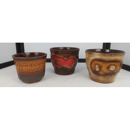114 - A group of three West German studio pottery planters, each with thick brown glaze interiors and mott... 