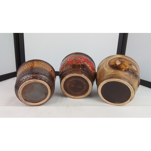 114 - A group of three West German studio pottery planters, each with thick brown glaze interiors and mott... 