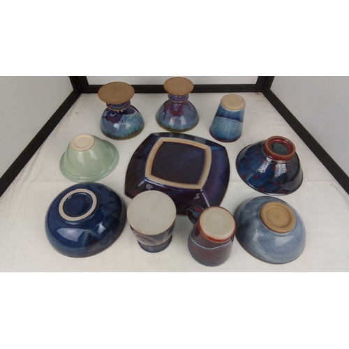 120 - A group of studio pottery table wares comprising footed bowls, a square dish, bowls and beakers, and... 