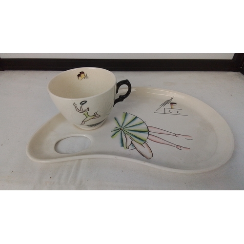 Clarice Cliff ‘Cruiseware’ Bizarre hand-painted pottery breakfast set—an oval tray with cup recess and egg-cup aperture, and a matching cup with black loop handle; decorated with stylised figures and ocean-liner motifs.