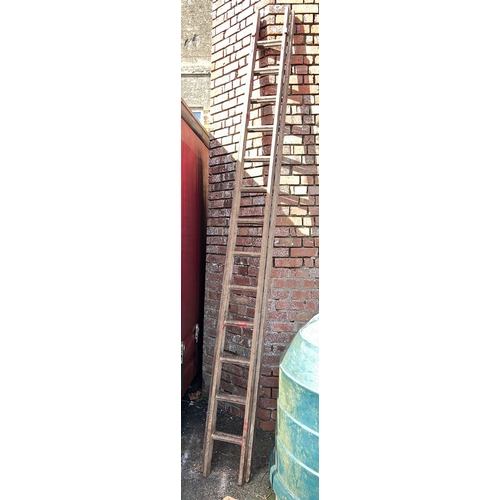 23 - A set of large extending wooden ladders.