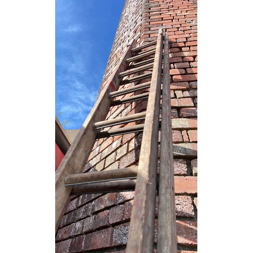 23 - A set of large extending wooden ladders.