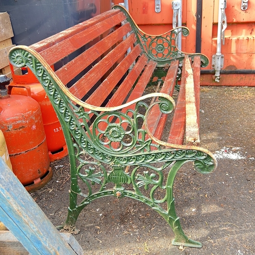 54 - Garden bench with red-painted slatted timber seat and back, on green cast-iron ends with pierced flo... 