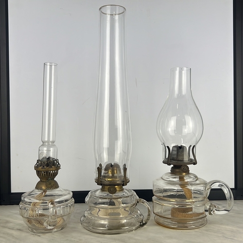 151 - Three vintage oil lamps and chimneys.