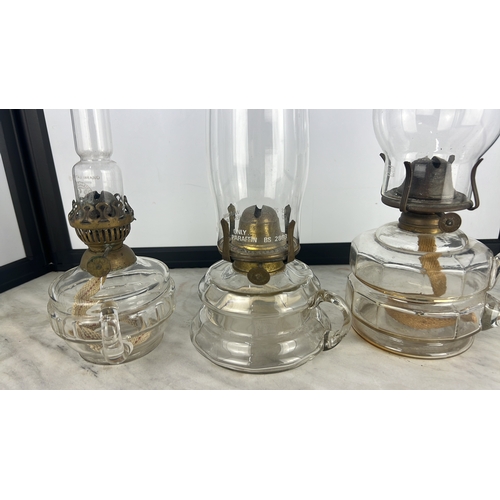 151 - Three vintage oil lamps and chimneys.