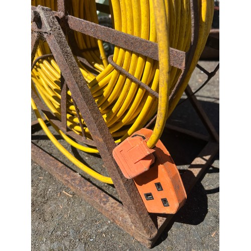 52 - A large extension lead on a cast iron reel stand.