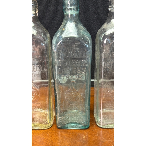 28 - A group of vintage moulded-glass bottles for The Old Bushmills Distillery Co. Limited, with embossed... 