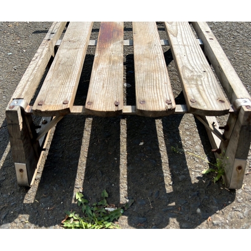 24 - Wooden snow sled with slatted platform and curved runners, fitted with a transverse handlebar and ro... 