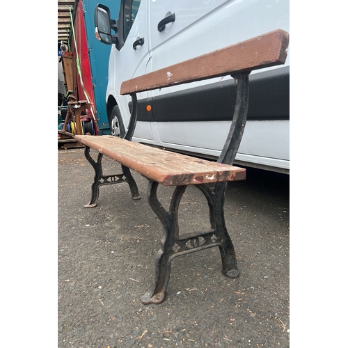 69 - Early 20th century cast-iron and timber bench, the plank seat and backrest on shaped iron end suppor... 