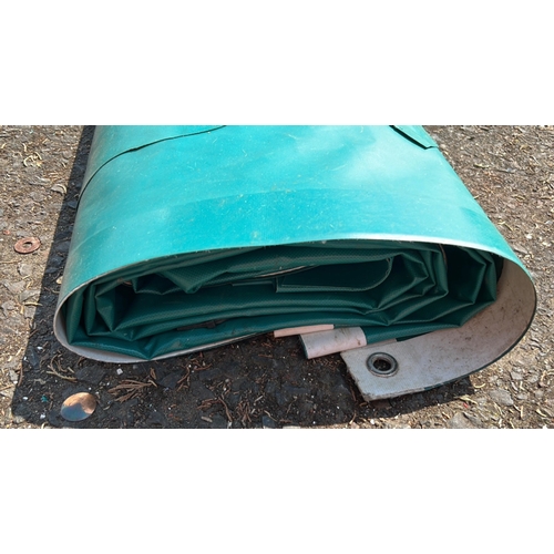 8 - Green tarpaulin, folded; the reinforced border fitted with metal eyelets and a rope edge, suitable f... 