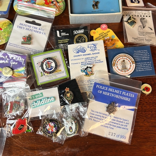 A collection of enamel lapel badges and pictorial pin-back buttons ...