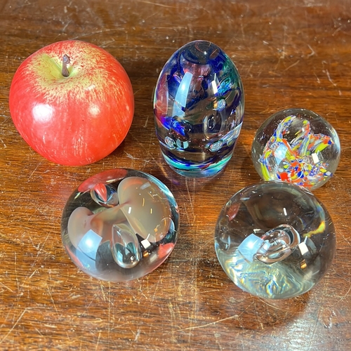 A group of four glass paperweights: an ovoid example with cobalt-blue ...