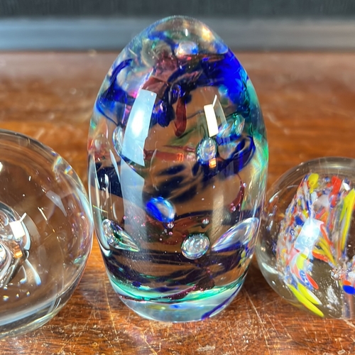 A group of four glass paperweights: an ovoid example with cobalt-blue ...