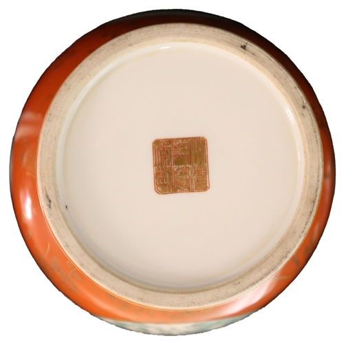 108 - A CHINESE CORAL-RED GROUND FAMILLE ROSE, CIRCA 1900, with an apocryphal Qianlong mark, with panels d... 