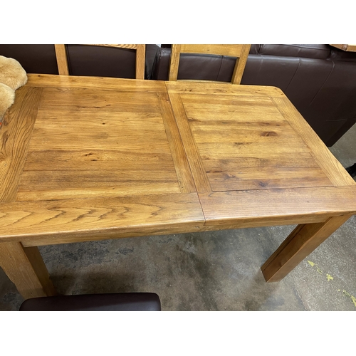 57 - MATCHING OAK EXTENDING DINING TABLE AND FOUR LADDERBACK CHAIRS