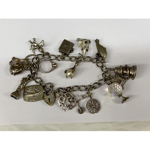 526 - SILVER CHARM BRACELET WITH HEART PADLOCK AND VARIOUS NOVELTY CHARMS 1.4OZ APPROX