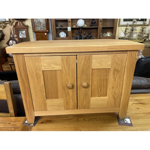 55 - CONTEMPORARY SMALL OAK TWO DOOR CANTED MEDIA CUPBOARD