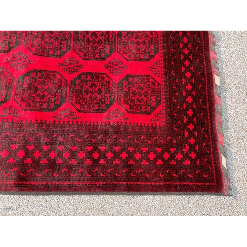 205 - LARGE RED AND BLACK FRINGED CARPET 292CM X 205CM