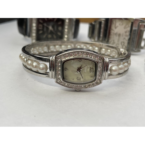 401 - BAG CONTAINING FOUR LADIES STAINLESS STEEL AND CZ ENCRUSTED DRESS WRIST WATCHES