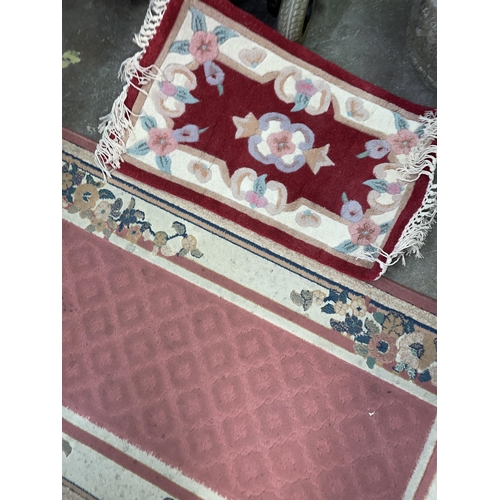 77 - PINK PATTERED CARPET RUNNER AND A DEEP RED SMALL RUG