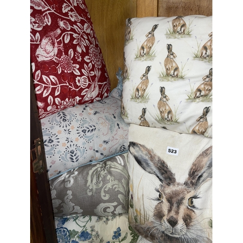 523 - SELECTION OF DECORATIVE CUSHIONS INCLUDING FLORAL AND RABBIT EXAMPLES AND SOME BLANKETS