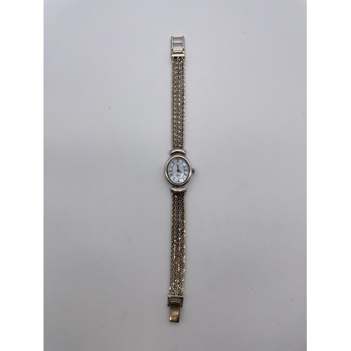 596 - LADIES OVAL FACE QUARTZ WRIST WATCH WITH MOTHER OF PEARL DIAL ON A SILVER THREE STRAND STRAP