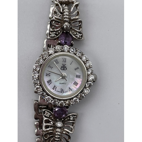 597 - LADIES SILVER QUARTZ CIRCULAR DIAMANTE AND BUTTERFLY STRAP DRESS WATCH