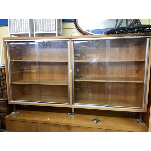 89 - TEAK GLASS SLIDING DOOR DOUBLE CABINET ON CHROME LEGS height 108cm x width 186cm x depth 37cm approx