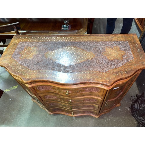 105 - BURMESE ROSE WOOD CARVED AND BRASS TENDRIL INLAID SERPENTINE CHEST OF DRAWERS