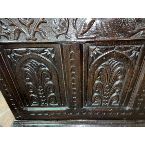 29 - JACOBEAN STYLE OAK COFFER, THE FRONT CARVED WITH LANCET ANTHEMION PANELS RAISED ON STILE FEET
