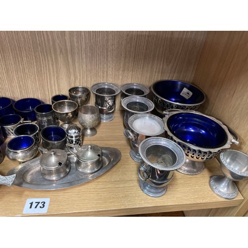 173 - SHELF OF EPNS WARES INCLUDING EGG CRUET, MUSTARDS AND SALTS, LOOSE BLUE GLASS LINERS, CELTIC STYLE Q... 