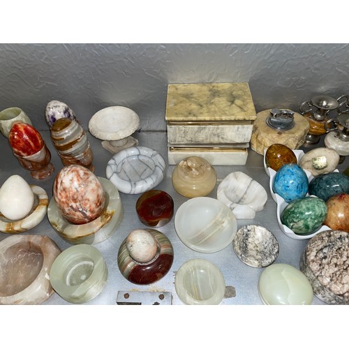 199 - SHELF OF ONYX AND ALABASTER ASHTRAYS, TABLE LIGHTERS, GOBLETS, AND EGGS