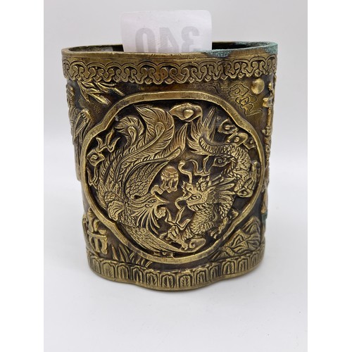 340 - CHINESE BRONZE LOBED POT DECORATED WITH FIGURES AND DRAGONS SCRIPT MARK TO UNDERSIDE 9cm x 8cm