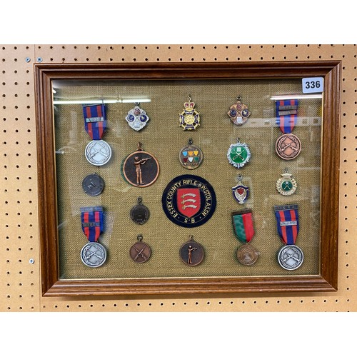 336 - CASED DISPLAY OF RIFLE AND PISTOL SHOOTING MEDALLIONS AND BADGES