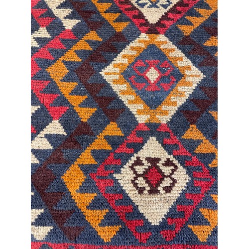 411 - DARK COLOURED HAND KNOTTED WOOL CARPET WITH GEOMETRIC PATTERN 132CM X 89CM