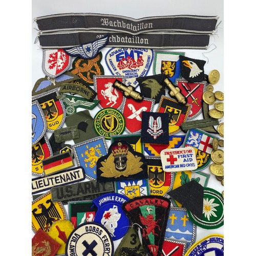 437 - BOX OF BRASS TUNIC BADGES, GERMAN AND OTHER SEW ON PATCHES, AND A TEATOWEL OF REGIMENTAL BADGES OF T... 